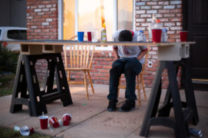 College student passed out on table because of college binge drinking.