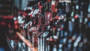 A row of alcohol bottles on a bar.