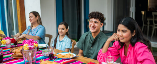 Family talking and eating during lunch at house yard