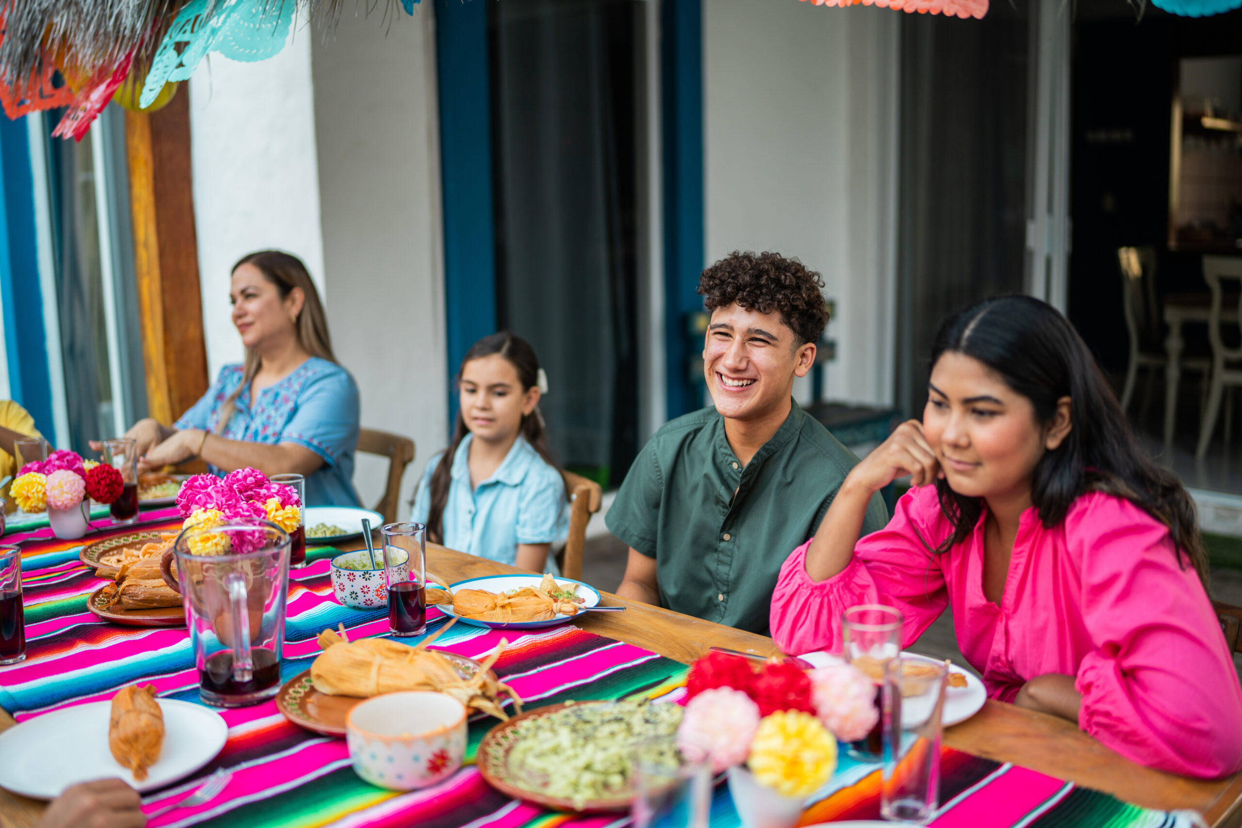 Family talking and eating during lunch at house yard