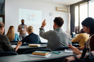 Adult raising hand in school classroom