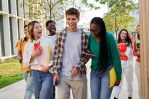 Cheerful group of multi-ethnic students walking towards the camera going to university classes.