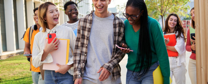 Cheerful group of multi-ethnic students walking towards the camera going to university classes.
