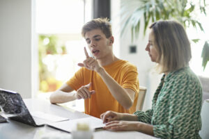 Teenage boy signing while e-learning from home