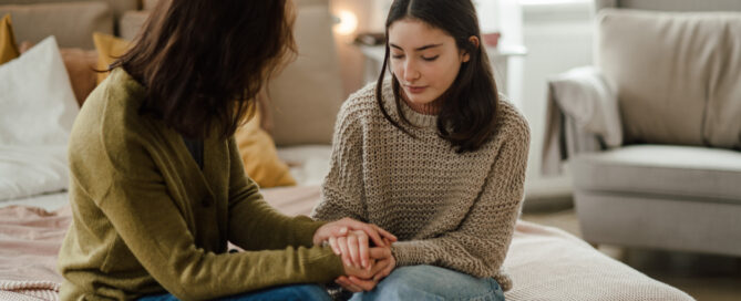 Teenage girl sharing problems with her mother in the room.