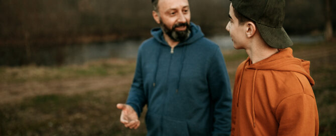 Mature man and his son walking in the public park