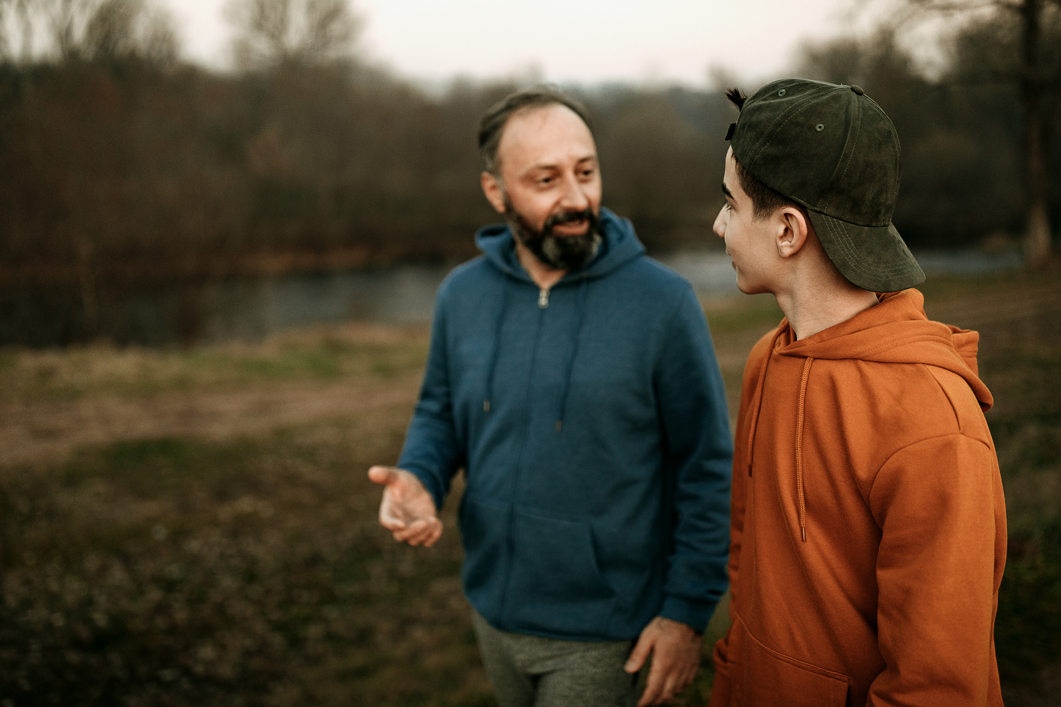 Mature man and his son walking in the public park