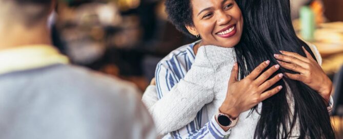A happy embrace of a female adult and a female teen in thin crowd