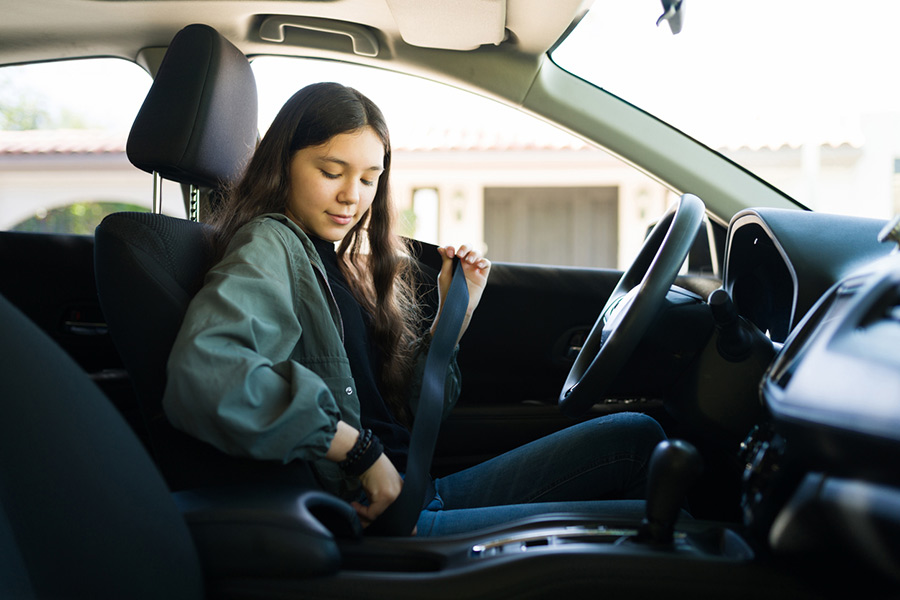 A teen girl driving a car