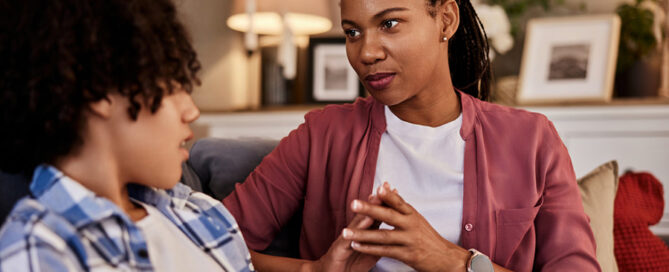 A mother having a conversation with her son on the couch